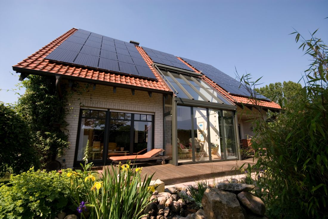 Einfamilienhaus mit Photovoltaikanlage in Moers auf rotem Ziegeldach bei Sonnenschein