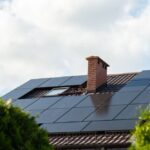 Dach eines Wohnhauses in Moers mit schwarzer Photovoltaikanlage und Schornstein